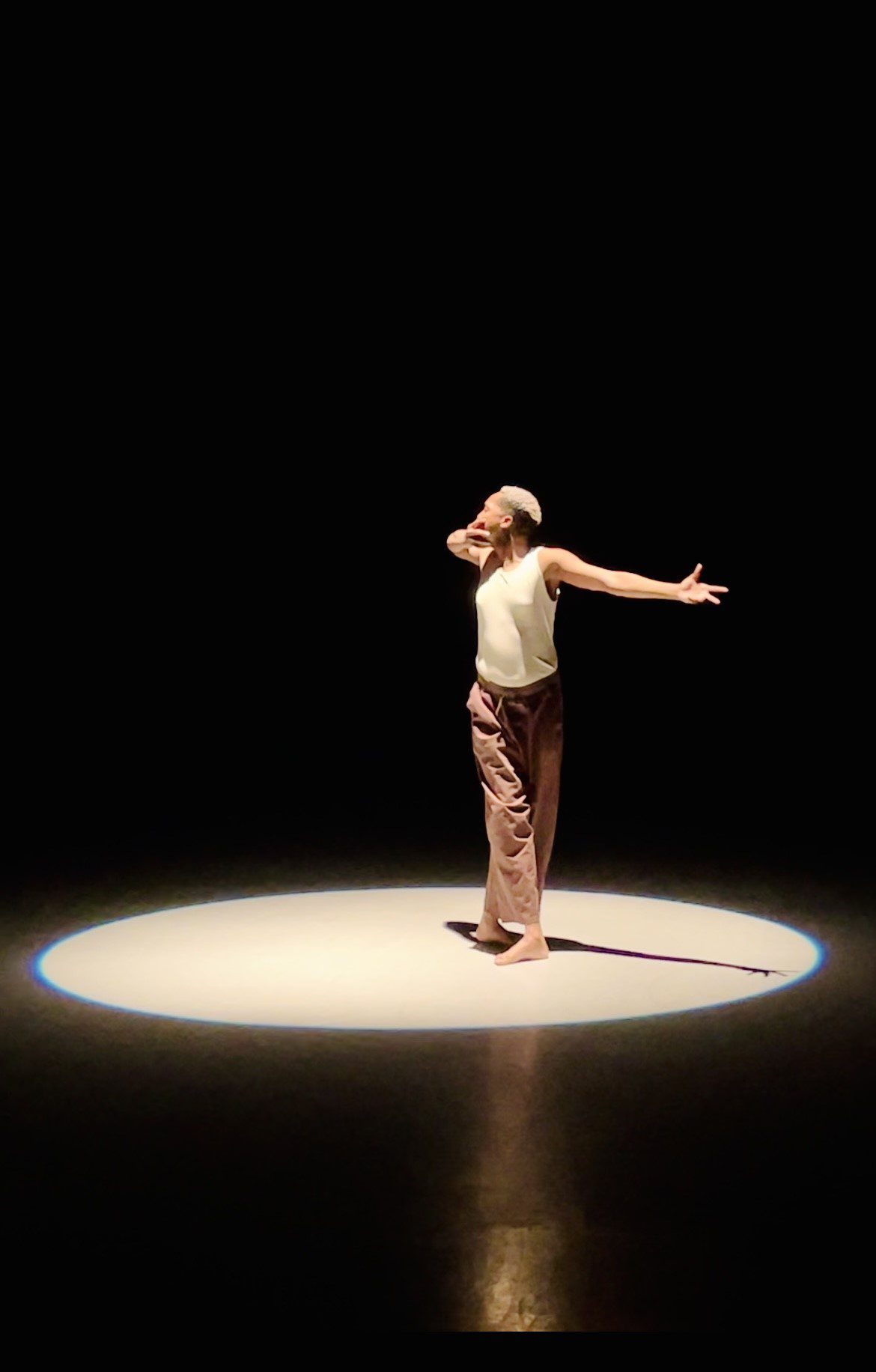 Dancer standing solo in a spotlight.