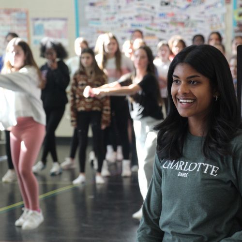 student in front of a classroom teaching dance