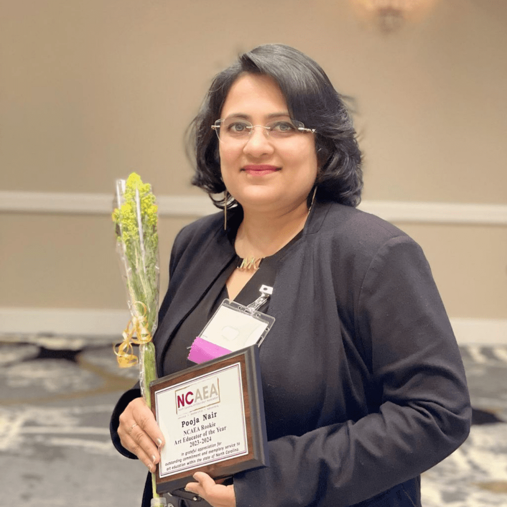 Photo of Pooja holding her teaching award