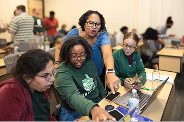teacher helping students in a classroom